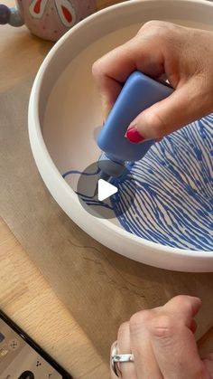 a person using a blue and white object in a bowl