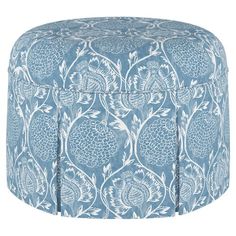 a blue and white poufle ottoman with floral designs on the top, sitting in front of a white background