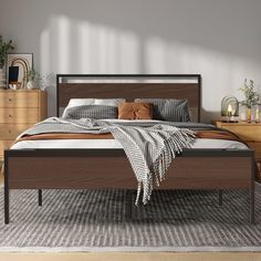 a bed sitting on top of a wooden floor next to a dresser