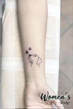 a woman's wrist tattoo with a dog and flowers on the left side of her arm