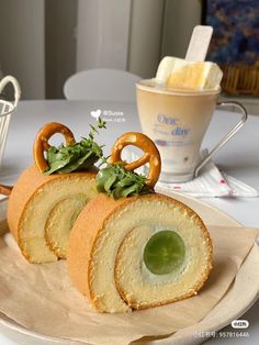 two pieces of bread with pretzels and greens on top sitting on a plate