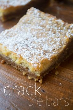 a wooden cutting board topped with two pieces of cake covered in powdered sugar on top of it