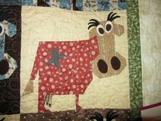 a close up of a quilt with a cow on it