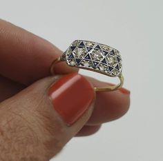 a woman's hand holding a diamond and sapphire ring