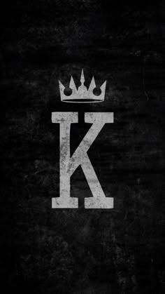 the letter k with a crown on it is painted in white and has black grunge