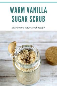 a jar filled with sugar next to a cookie on top of a white wooden table