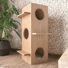 two wooden speakers sitting next to each other in front of a potted plant on the floor