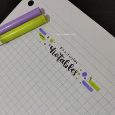 two pens sitting on top of a piece of paper with the words happy holidays written on it