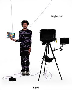 a man standing next to a tripod holding an object