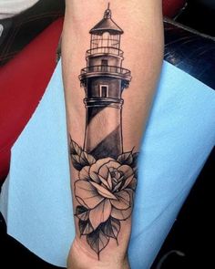 a black and white photo of a lighthouse with flowers on it's leg,