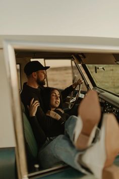 a man and woman sitting in the driver's seat of a car