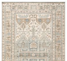 a beige and blue rug with an intricate design on the bottom, in front of a white background