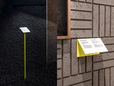 a yellow post in front of a brick wall