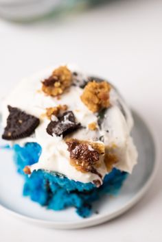 an ice cream dessert on a plate with cookies and oreo pieces around it, ready to be eaten