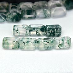 some green and white glass beads sitting on top of a table next to each other