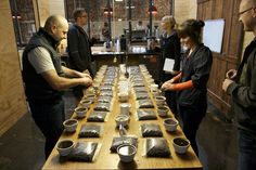 several people standing around a table with cups on it