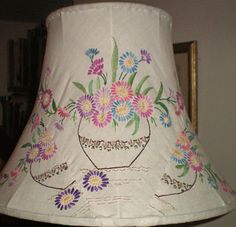 a lamp shade with flowers painted on it