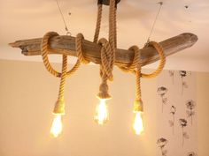 a chandelier made out of wood and rope with light bulbs hanging from it