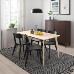 a dining room table with chairs and a rug