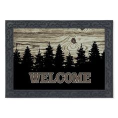 a welcome mat with trees and the word welcome on it's front door frame