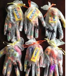 five halloween hand treat bags in the shape of hands with candy on them, all wrapped in plastic