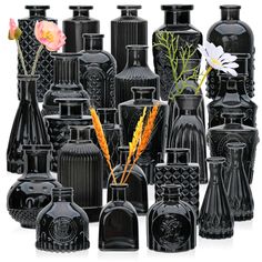 a group of black vases with flowers in them on a white background, including one that is surrounded by smaller ones