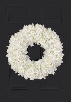 a white wreath on a black door