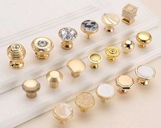 there are many different types of knobs on this white board with gold trimming