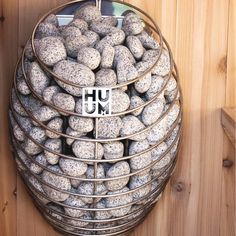 a metal basket filled with rocks on top of a wooden wall