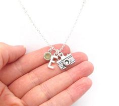 This personalized camera necklace features a silver toned camera charm, silver toned initial charm, and a Swarovski crystal birthstone charm- initial and birthstone of your choice. This necklace is a great gift for photographers!MATERIALS:+ Necklace is composed of silver plated components.+ Camera charm is zinc alloy. + Letter charm is zinc alloy.+ Bead is a Swarovski crystal element birthstone. (Colors may vary slightly from monitor to monitor.)+ January and July birthstones are the same Siam ( Silver Everyday Charm Necklaces With May Birthstone, Silver Charm Necklace With May Birthstone For Everyday, Everyday Silver Charm Necklace With May Birthstone, Silver Vintage Charm Initial Pendant Jewelry, Silver Vintage Charm Jewelry With Initial Pendant, Silver Birthstone Charms For Everyday, Silver Jewelry With Vintage Charm Initial Pendant, Everyday Silver Birthstone Charms, Necklace Photography