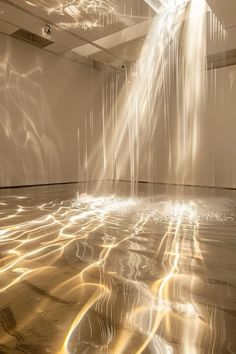 an empty room with white walls and light streaming from the ceiling into the floor in front of it