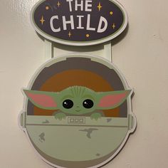 a star wars baby yoda sign hanging on the wall