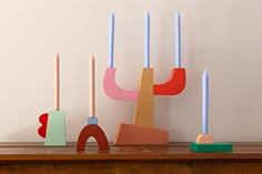 a wooden table topped with different colored candles