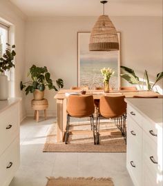 a dining room table with chairs and plants