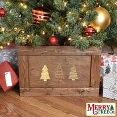 a christmas tree with presents under it and a wooden box on the floor next to it