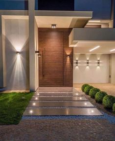 a modern house with lights on the front door