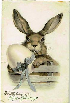 an old easter card with a rabbit in it's lap holding a piece of paper