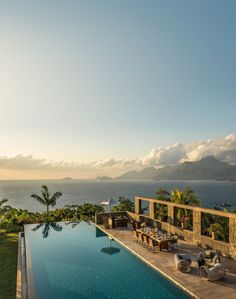 an outdoor swimming pool next to the ocean