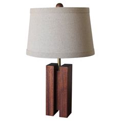 a lamp that is sitting on top of a wooden block with a light shade over it