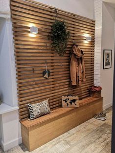 a wooden bench sitting in front of a wall mounted coat rack with lights on it