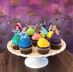 there are cupcakes that have been decorated with princesses on top of them