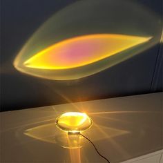 a yellow light shines brightly on a table with a glass bowl in the foreground