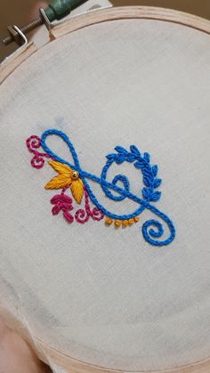 someone is stitching something on the back of a hand embroidery project with scissors and thread