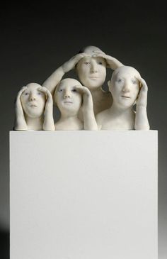 a group of white sculptures sitting on top of a white block