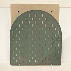 a metal grate mounted to the side of a white wall with holes in it