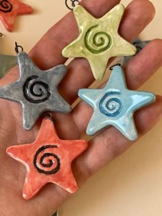 three star shaped ornaments are being held in someone's hand with spiral designs on them