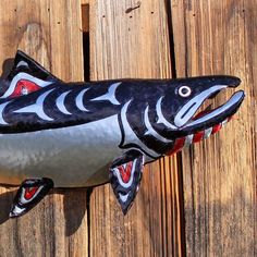 a ceramic fish on a wooden fence