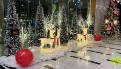 christmas decorations are displayed in the lobby of an office building, decorated with white and red trees