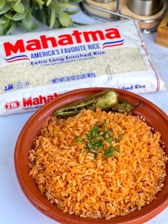 a bowl filled with rice and vegetables next to a bag of mahama rice