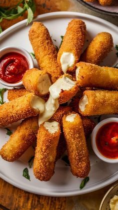 some fried food on a white plate with ketchup and sauces next to it